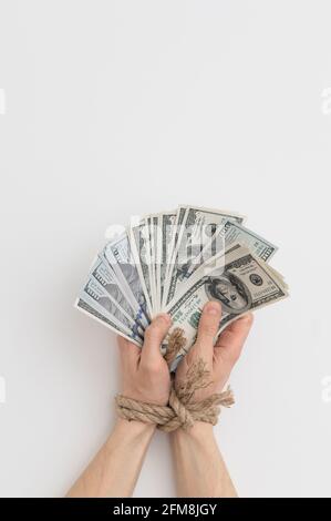 bound hands hold the money. Dependence on money. Credit, mortgage Stock Photo