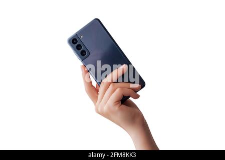 Woman hand shows a modern phone with three cameras on the back. Isolated background Stock Photo