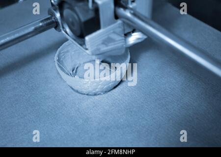 Work 3d printer close up. Printing 3D printer Object plastic On blue background. Stock Photo