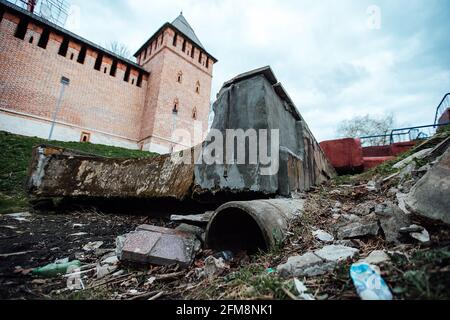 an old dried-up pond in mud and garbage. an abandoned park near the old fortress. desolation in the city of a poor country. the stone bowl of the foun Stock Photo