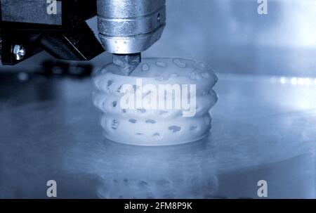 3D printer prints bkue gray form figure close Stock Photo