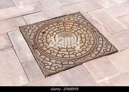 Samara, Russia - May 4, 2021: Metal cover manhole on the pavement road Stock Photo