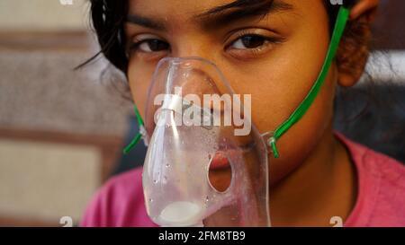 30 April 2021- Reengus, Sikar, India. Little cute girl infected with Covid virus. Girl admitted in hospital and receiving inhalation from Oxygen mask. Stock Photo