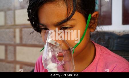 30 April 2021- Reengus, Sikar, India. SARS n- Covid infection in India. Little girl suffering from cold flu virus and inhalation with oxygen supply ma Stock Photo