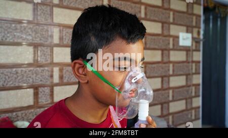 30 April 2021- Reengus, Sikar, India. Closeup up of a sick boy sitting in hospital with the facial mask. Nasal cannula or Oxygen mask for Covid patien Stock Photo