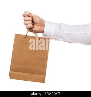 A persons hand gives a paper bag and at the same time shows a combination of three fingers, denotes deception, isolated on white background. Stock Photo