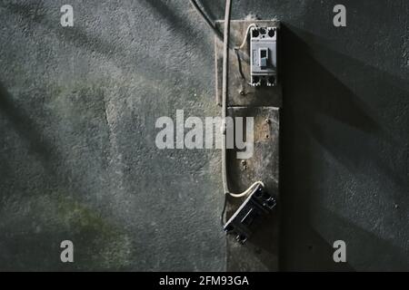 Old electrical outlet on gray concrete wall Stock Photo