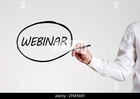 Businessman writes the word webinar with an outline circle. Stock Photo