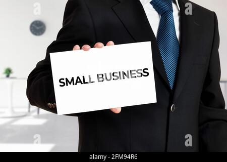Businessman holds a card with the word small business. Business entrepreneurship concept. Stock Photo