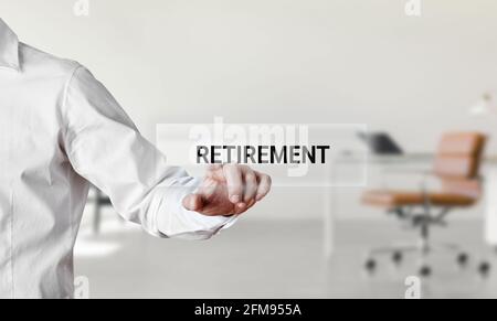Businessman pressing the word retirement on a virtual search display screen. Retirement and pension concept. Stock Photo