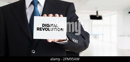Businessman shows a business card with the message digital revolution. Digital revolution in business industry concept. Stock Photo