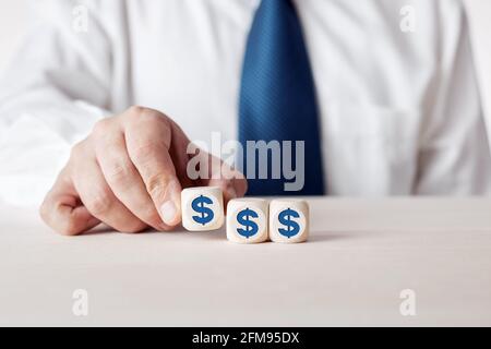 Businessman placing the wooden cubes with US dollar symbol. Financial growth, profit, investment or savings in business and finance concept. Stock Photo