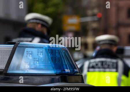 Freiburg, Germany. 05th May, 2021. Two police officers are standing between two police emergency vehicles. Credit: Philipp von Ditfurth/dpa/Alamy Live News Stock Photo