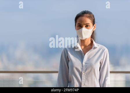 Asian woman wearing face mask to protect from coronavirus Covid-19 horizontal shot Stock Photo