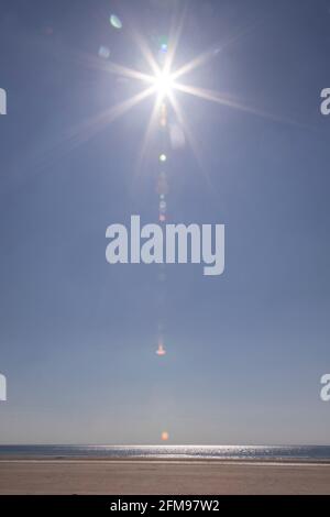 Sunstar over Harlech beach, Gwynedd, Wales Stock Photo