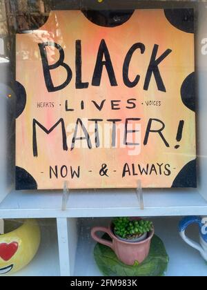 Cereamic plaque in the wi9ndow of a pottery business paying tribute to  Black lives Matter and universal equality for all people. Stock Photo