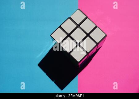 Rubik's cube white side on a pink blue table with black shadow. Stock Photo