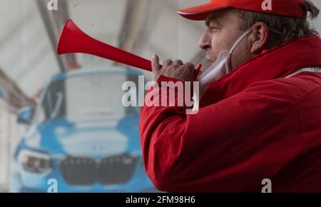 Leipzig, Germany. 07th May, 2021. A participant in a strike action by IG Metall stands in front of the BMW plant in Leipzig. In the collective bargaining dispute in the metal industry, IG Metall has called on the employees of the BMW plant to go on a 24-hour warning strike. The union is demanding, among other things, four percent pay increases and an improvement in the transfer regulations for trainees. Credit: Hendrik Schmidt/dpa-Zentralbild/dpa/Alamy Live News Stock Photo