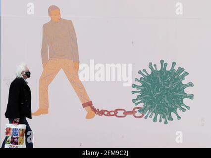 A man walks past part of the 'IN THESE STRANGE TIMES: an evolving series created in response to the pandemic' exhibition at the Science Gallery in Dublin's city centre. There have been four further deaths linked to Covid-19 and an additional 434 confirmed cases, the Department of Health has said. Dr. Holohan has called for caution as the country continues to open up. Picture date: Friday May 7, 2021. See PA story IRISH Coronavirus. Stock Photo