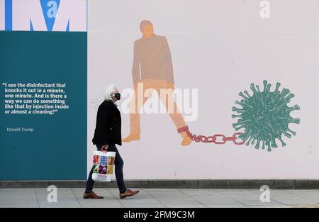 A man walks past part of the 'IN THESE STRANGE TIMES: an evolving series created in response to the pandemic' exhibition at the Science Gallery in Dublin's city centre. There have been four further deaths linked to Covid-19 and an additional 434 confirmed cases, the Department of Health has said. Dr. Holohan has called for caution as the country continues to open up. Picture date: Friday May 7, 2021. See PA story IRISH Coronavirus. Stock Photo