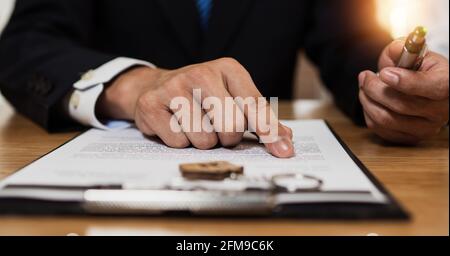 Check and read contract thoroughly before signing, close up hand of businessman reading and checking business document and sign on paper Stock Photo