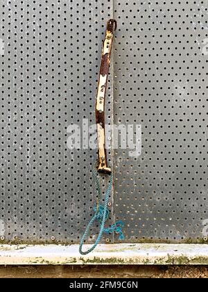 Broken pull handle on perforated metal security sceen Stock Photo