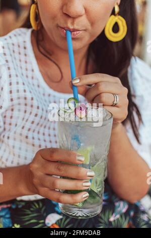 Close-up cropped image of young woman drinking mojito cocktail in summer. Stock Photo