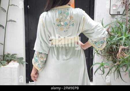 Moroccan model wears a Moroccan caftan. The caftan is a long, flowing type of robe-like dress that is often worn in Morocco. Stock Photo