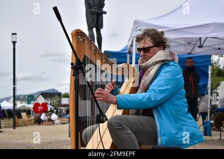 Bantry, West Cork, Ireland. 7th May, Streets of Bantry we're busy today as it is first market of the month, musician playing harp at Bantry market. Credit: Karlis Dzjamko/Alamy Live News Stock Photo