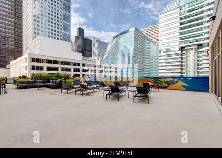 A rooftop patio in Chicago with a garden and chairs looking out over the city. Stock Photo