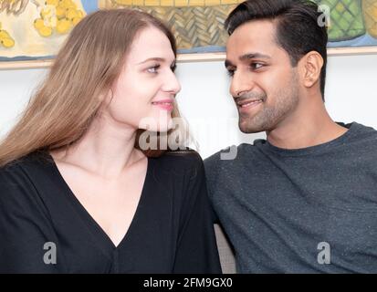 Happy Asian man and Caucasian woman watching tenderly to each other Stock Photo