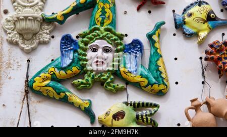 Italy, Sicily, Santo Stefano di Camastra, pottery village, pottery, display, ceramics, trinakria with Medusa head in the middle as ceramic, hanging on the wall Stock Photo