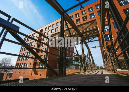 Hamburg, Germany - April 17, 2018: Famous landmark old Speicherstadt in Hamburg, build with red bricks. Bridge in low angle view.. Stock Photo