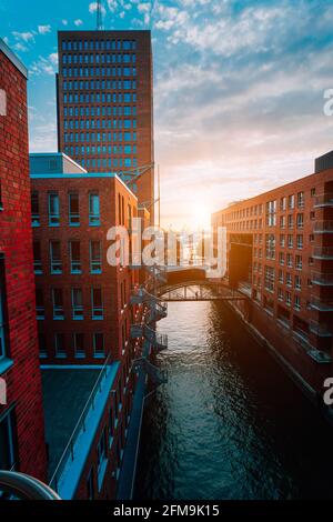 HafenCity. Bridge over canal and red brick buildings in the old warehouse district Speicherstadt in Hamburg in golden hour sunset light, Germany. View from above. Stock Photo