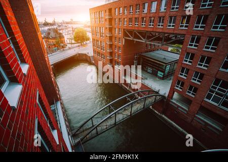 HafenCity. Bridge over canal and red brick buildings in the old warehouse district Speicherstadt in Hamburg in golden hour sunset light, Germany. View from above. Stock Photo