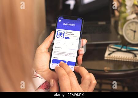 Kharkov, Ukraine - April 27, 2021: Woman use Aviasales app for searching flight ticket Stock Photo