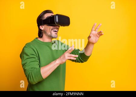 Photo portrait of bearded man playing game virtual reality wearing glasses smiling isolated on vivid yellow color background Stock Photo