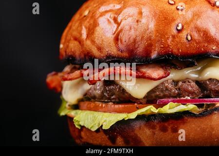 Juicy and sliced ​​burger with meat cutlet close up. on a black background. Stock Photo