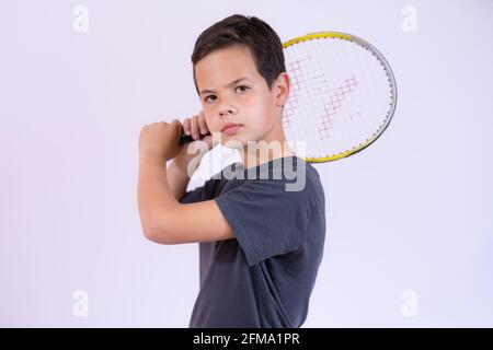 Cute young boy with tennis racket on white background Stock Photo