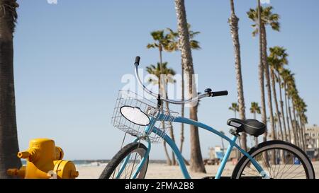 Blue bicycle cruiser bike by sandy ocean beach pacific coast near