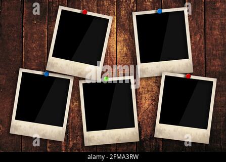 Close up five empty Polaroid instant photo frames pinned on old grunge brown wooden wall background, low angle, side view Stock Photo