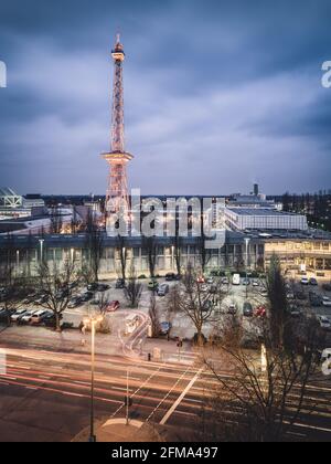 Road traffic in front of the illuminated Berlin radio tower on the exhibition grounds at dusk. Stock Photo