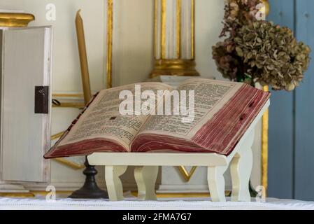 Sierpc, Poland - May 6, 2021: Missal in Latin on the altar in the old chapel. Old open book. Old liturgical accessories. Stock Photo