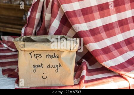 Tips Make Great Dough on a brown paper bag on a table covered with a red and white checkered tablecloth Stock Photo