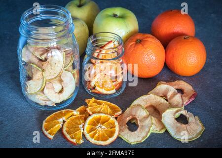 fresh fruit apples and oranges and apple and orange slices dehydrated and stored in glass containers, homemade preparations, Stock Photo