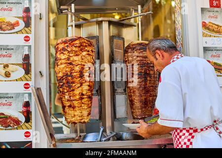 The chef prepares shawarma in a street counter in the open air. Turkish street food. Istanbul, Turkey - 28.07.2017 Stock Photo