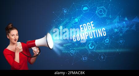 Young woman shouting in megaphone, technology announcement concept Stock Photo