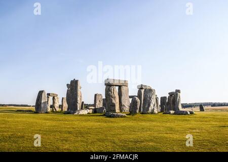 Standing rocks of ancient Stonehenge with defining shadows under clear blue sky on bright summer morning standing alone on Salisbury Plain Stock Photo