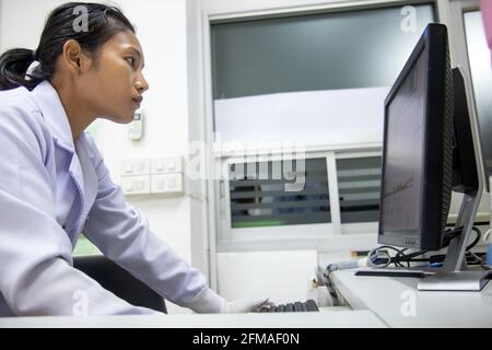 Medical staff checks registration on computer display. Night shifts works with the electronic card index at hospital. Stock Photo
