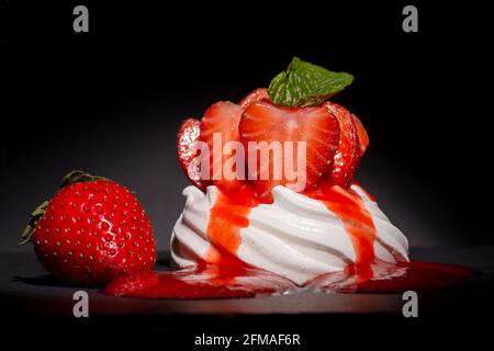Individual mini strawberry pavlova with strawberry coulis Stock Photo